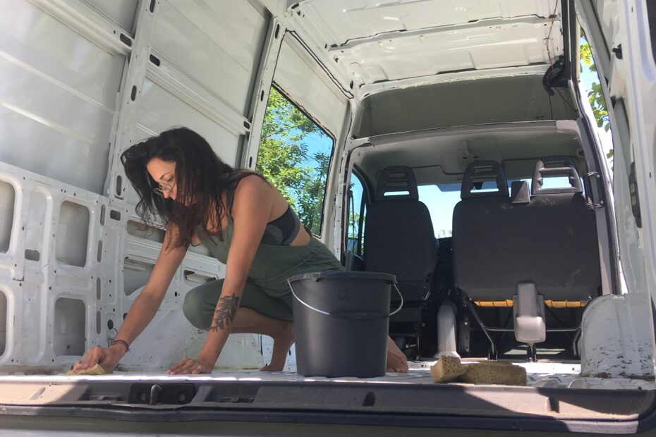 Carmen is cleaning the inside of the van on a summer day